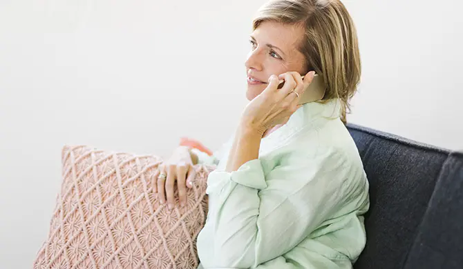 Woman on the phone sitting on a sofa