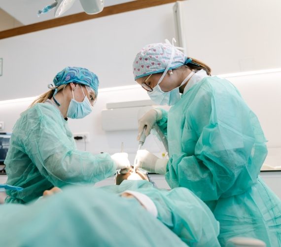 Dentists perform oral procedure on patient