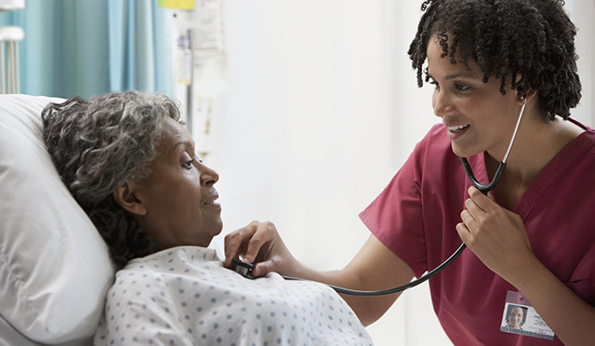 Doctor using stethoscope on patient 