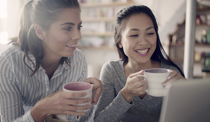 Two researchers researching whilst drinking coffee