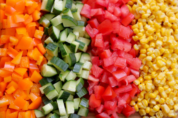 Diced orange pepper, cubumber, tomato, and corn kernels.